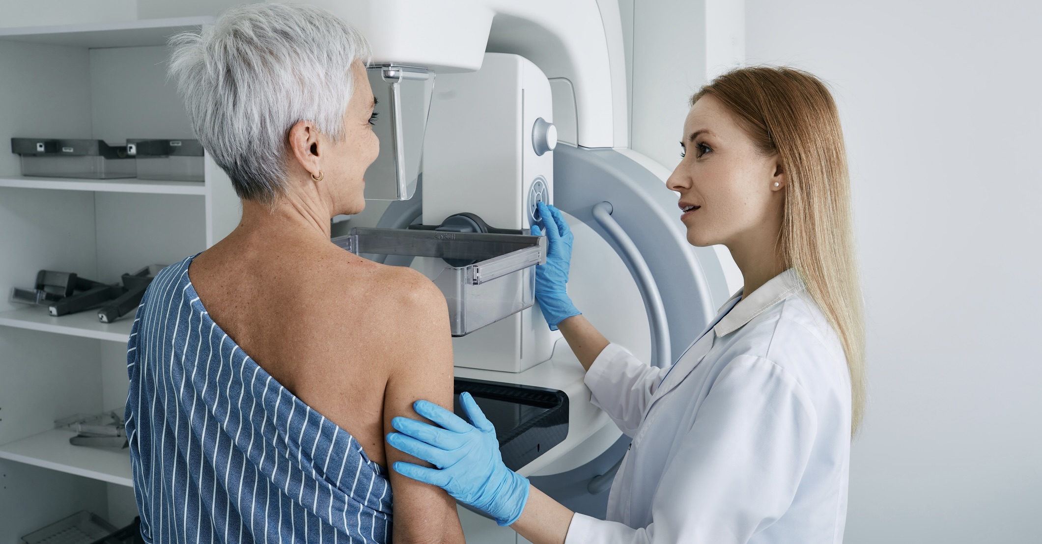 Senior woman having mammography scan at hospital with medical technician. Mammography procedure, breast cancer prevention